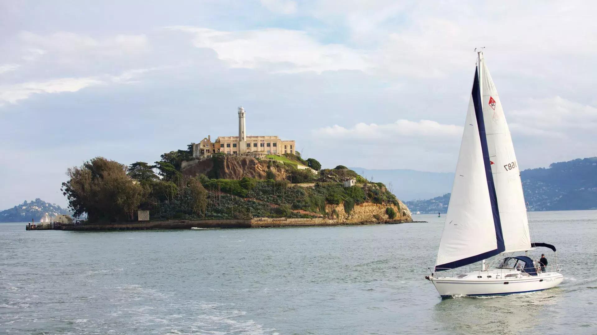 サンフランシスコのアルカトラズ島の前を帆船が通過します。