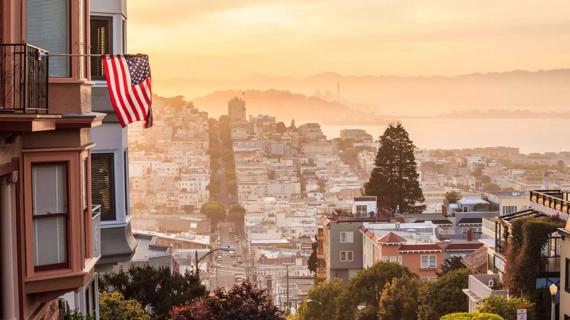 从山顶俯瞰贝博体彩app的景色, 前景中飘扬着一面美国国旗.