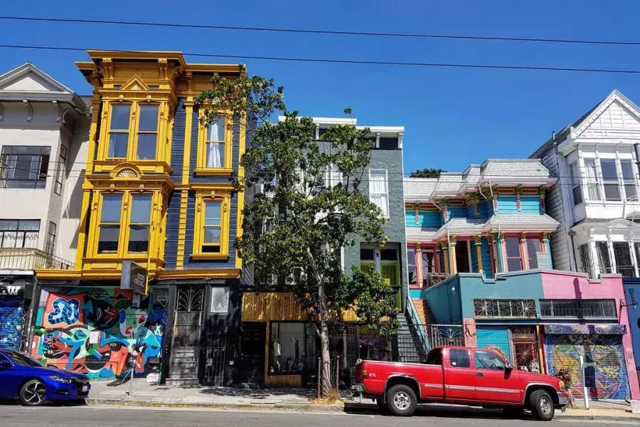 Vista degli edifici colorati su Haight Street con le auto parcheggiate lungo la strada. San Francisco, California.