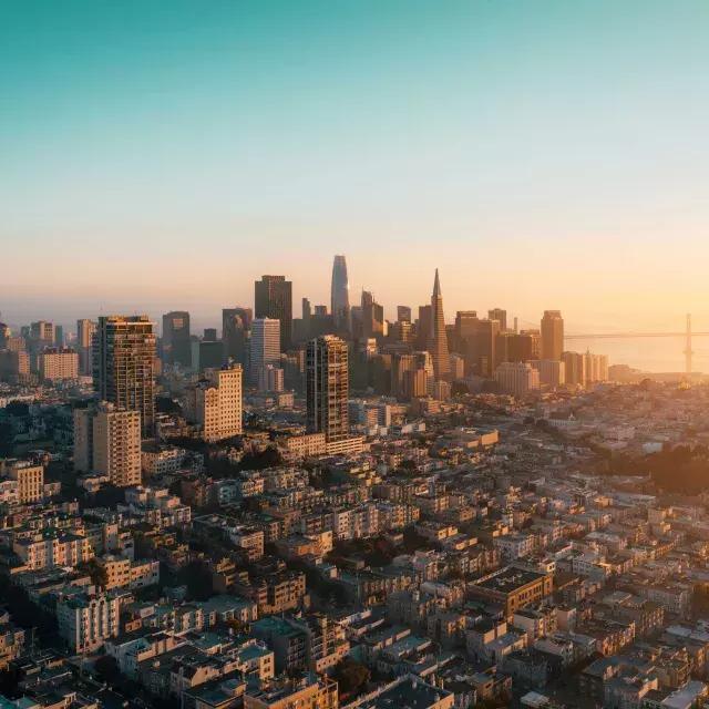 샌프란시스코의 스카이라인이 황금빛으로 공중에서 보입니다.