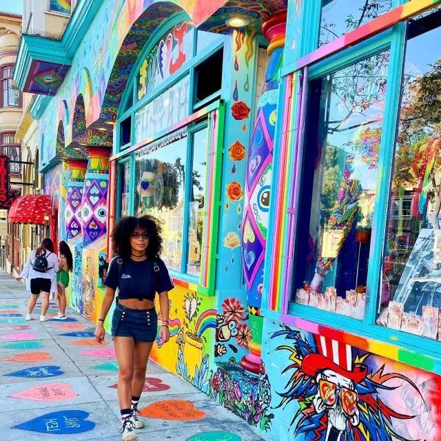 一个女人走在海特街与彩色壁画的背景.